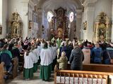 Man sieht eine volle Kirche und die Ministranten von hinten